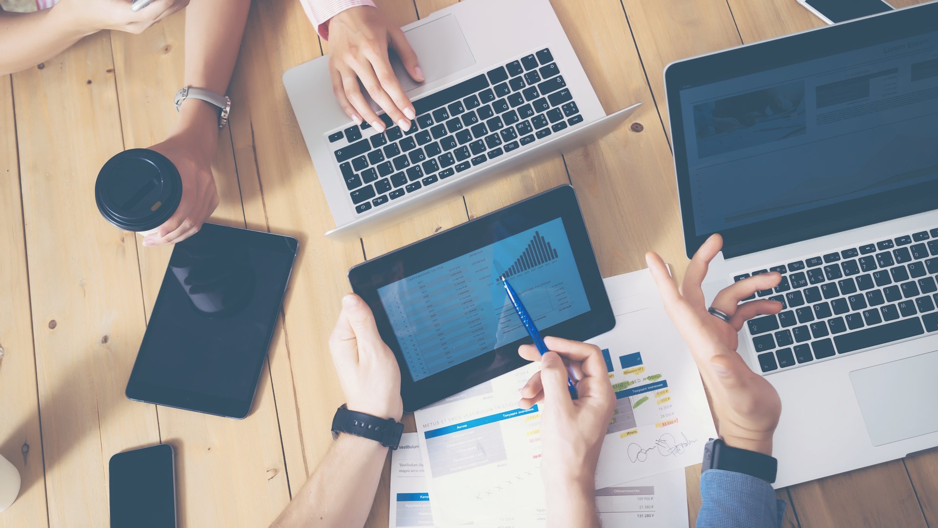 Generische Büro Szene Generisches Büro, mehrere Hände die über einen Tisch greifen Laptops und Tablets auf dem tisch